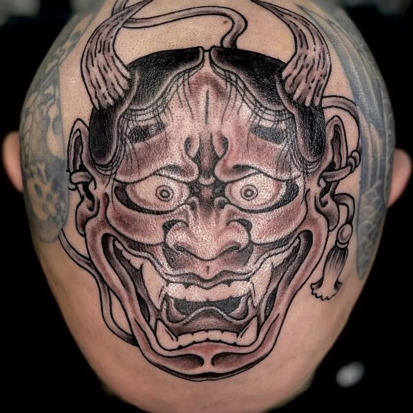 Top of a clients head, tattooed with the a traditional Japanese demon mask. This Hanna mask was tattooed in Brighton, UK by Antony Dickinson, northernbuilt at Nowhere Tattooing