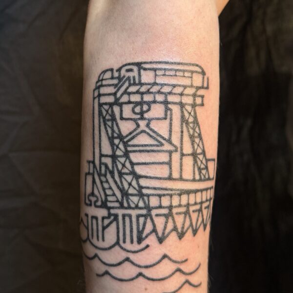 Hand-poked tattoo by Adam Sage, featuring smooth, precise linework and strong graphic composition. Inspired by brutalist architecture, children’s book illustration, and Soviet poster design, Adam creates timeless, non-electric tattoos with bold, simple forms.